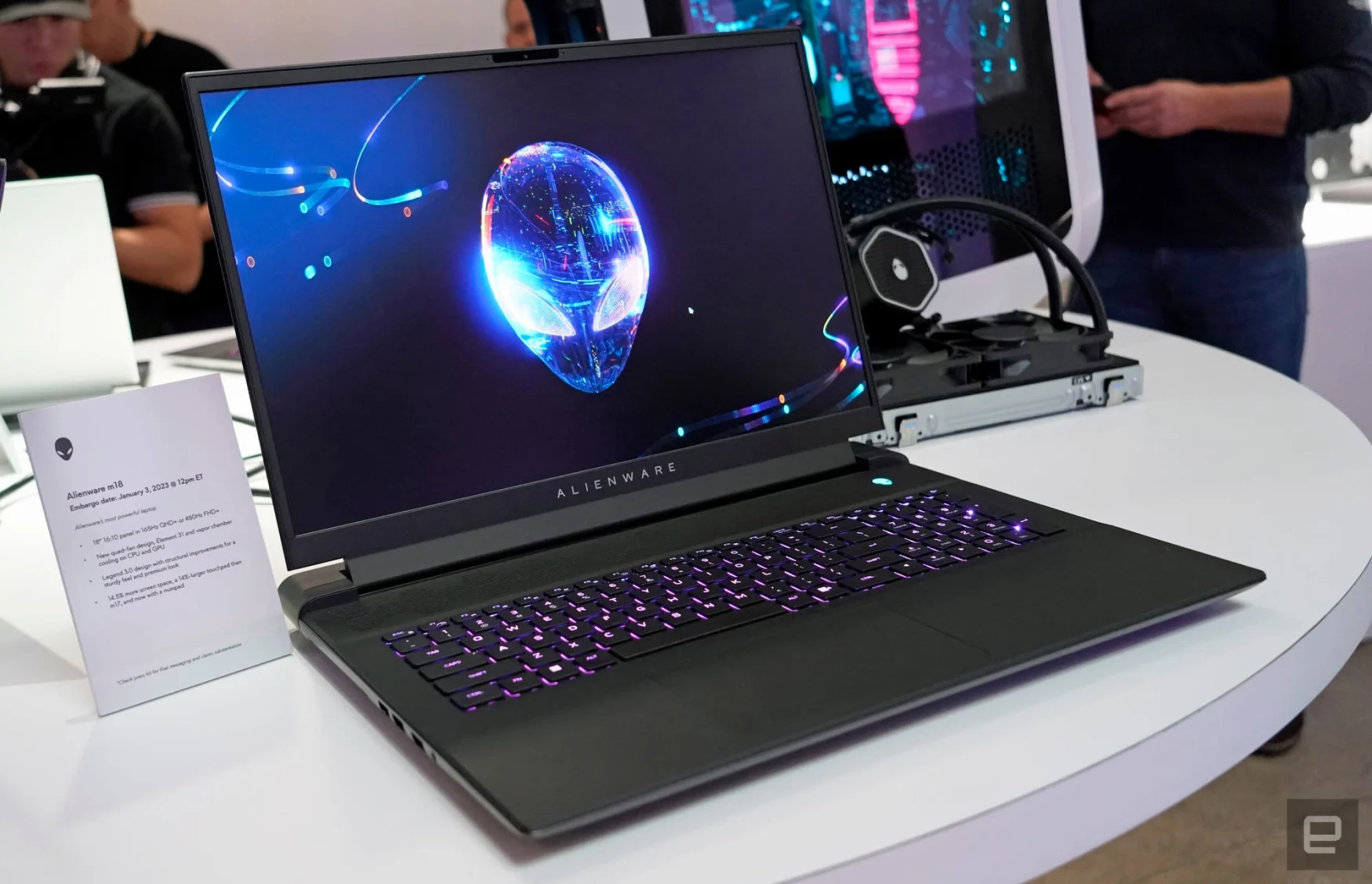 CES showroom photo of the Alienware m18 laptop. The dark-colored laptop sits on a white table with an alien logo on its screen.